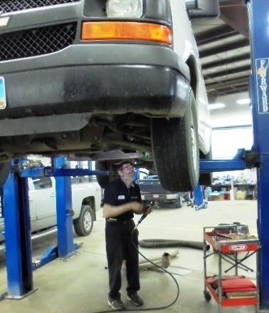 Mechanic underneath a lifted car